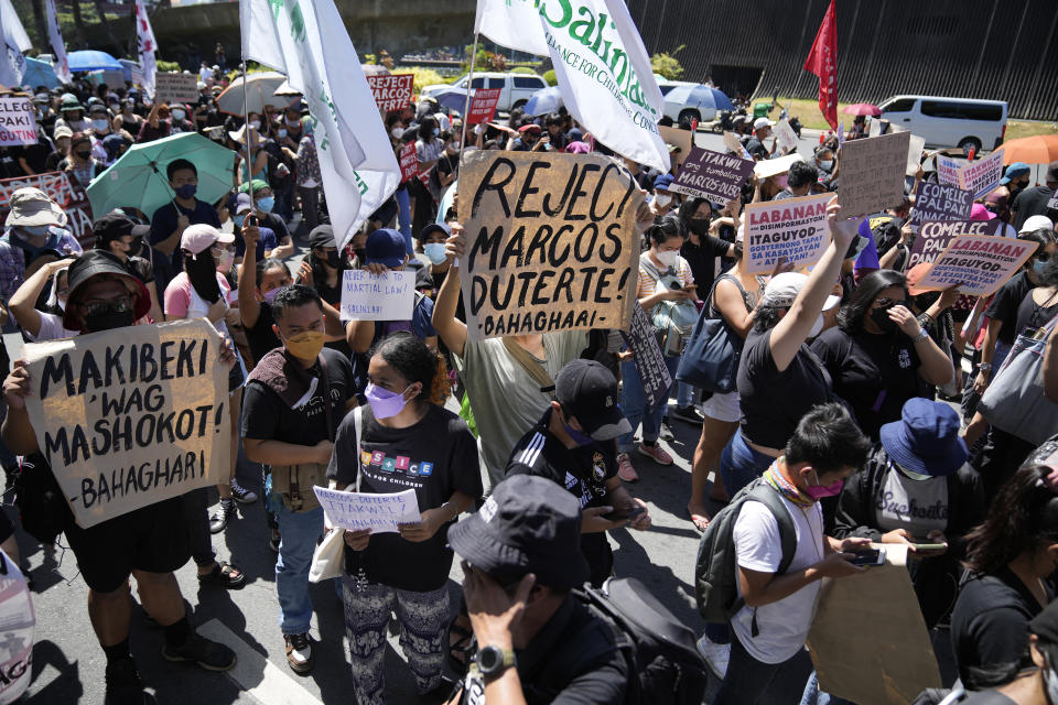 Protesters hold slogans during a rally against presidential frontrunner Ferdinand "Bongbong" Marcos and running mate Sara Duterte, daughter of the current president, during a rally in Pasay, Philippines, Friday, May 13, 2022. Allies of the Philippines' presumptive next president, Marcos Jr., appear set to strongly dominate both chambers of Congress, further alarming activists after the late dictator's son scored an apparent election victory that will restore his family to the seat of power. (AP Photo/Aaron Favila)