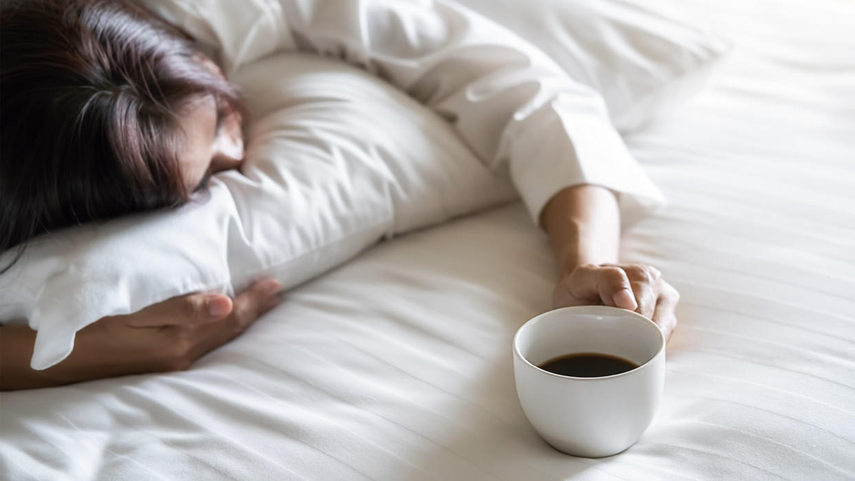  woman asleep holding a cup of coffee 