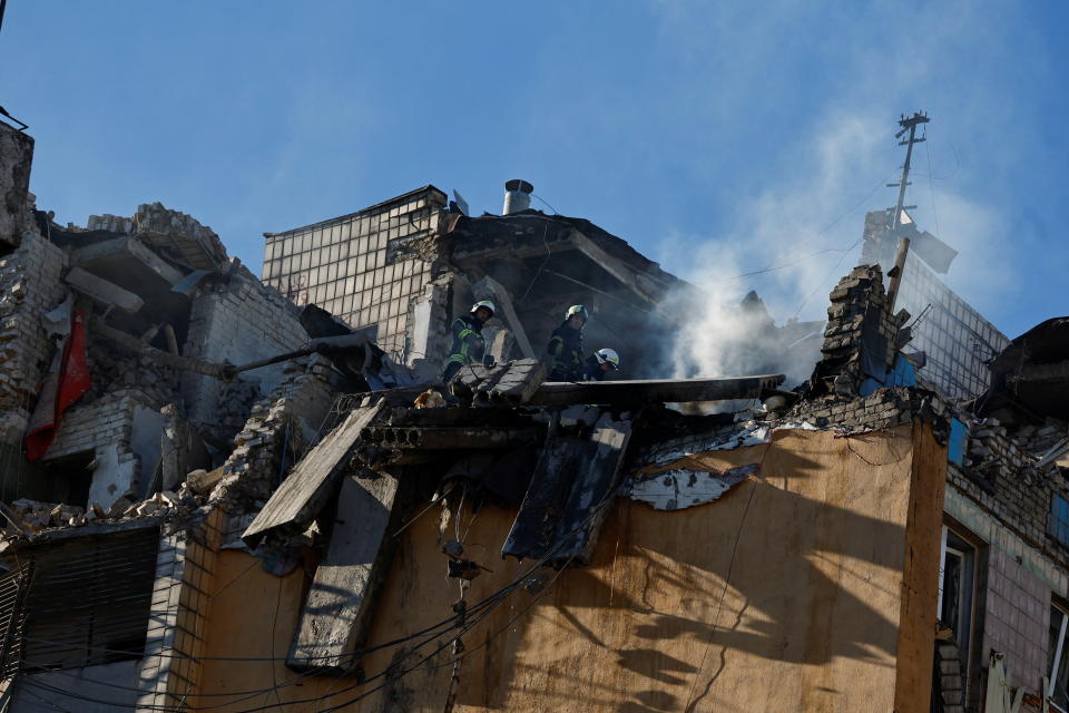 Rescuers work atop an apartment building that was hit by shelling, as Russia's invasion on Ukraine continues, in Kyiv, Ukraine March 16, 2022. REUTERS/Thomas Peter