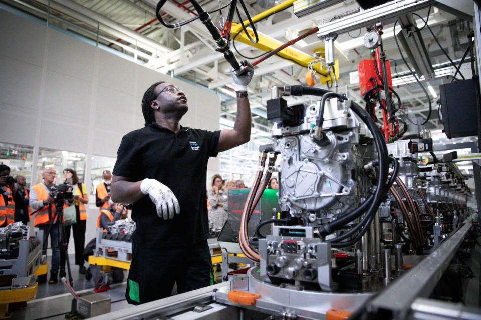 An employee works on electric car equipments, at a Renault factory, in Cleon, northwestern France, on July 5, 2022. (Photo by Lou BENOIST / AFP)