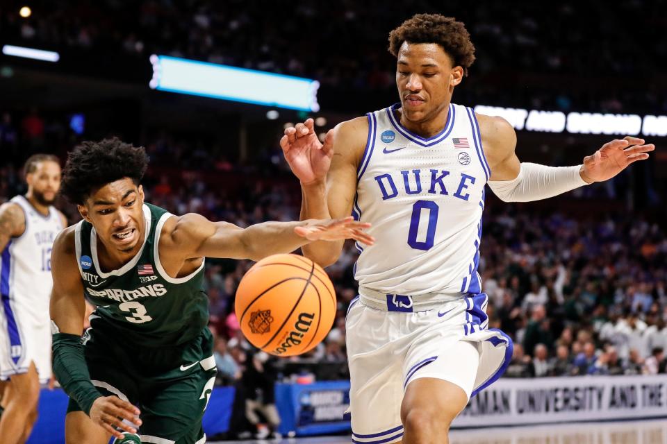 Michigan State guard Jaden Akins (3) and Duke forward Wendell Moore Jr. (0) battle for a loose ball during the first half of the second round of the NCAA tournament at the Bon Secours Wellness Arena in Greenville, S.C..