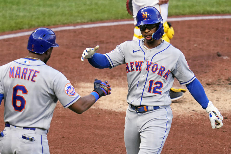 New York Mets' Francisco Lindor (12) is greeted by Starling Marte as he returns to the dugout after hitting a solo home run off Pittsburgh Pirates starting pitcher Rich Hill during the third inning of a baseball game in Pittsburgh, Friday, June 9, 2023. (AP Photo/Gene J. Puskar)