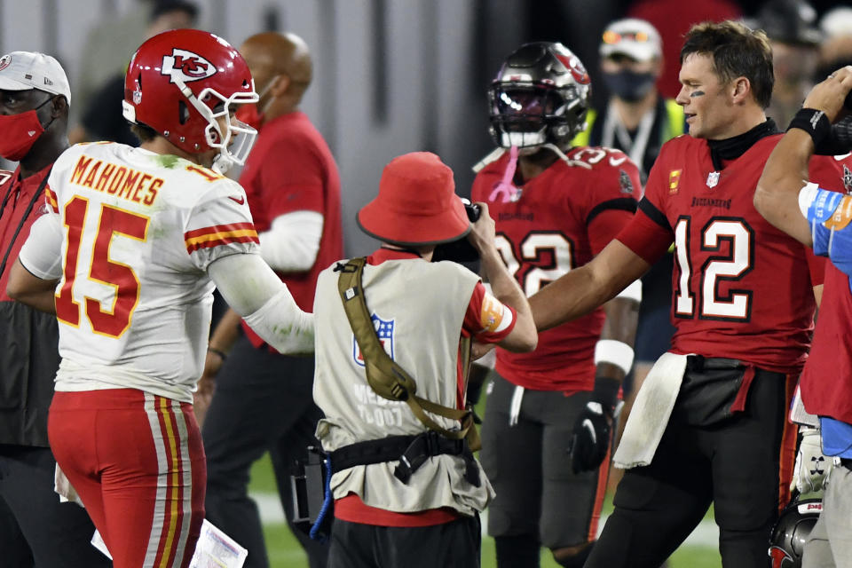 FILE- In this Nov. 29, 2020, file photo, Tampa Bay Buccaneers quarterback Tom Brady (12) congratulates Kansas City Chiefs quarterback Patrick Mahomes (15) after their NFL football game in Tampa, Fla. The Super Bowl matchup features the most accomplished quarterback ever to play the game who is still thriving at age 43 in Brady against the young gun who is rewriting record books at age 25. (AP Photo/Jason Behnken, File)