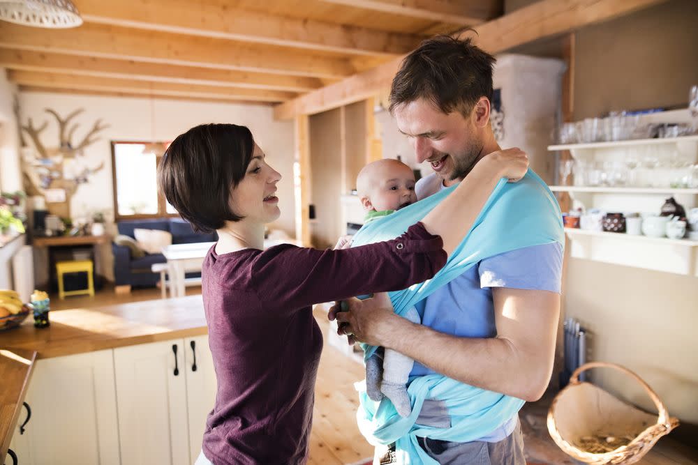 Mom Putting Baby in Sling for Husband to Carry