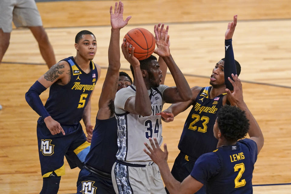 Georgetown's Qudus Wahab (34) passes away from Marquette's Greg Elliott (5), Jamal Cain (23), Justin Lewis (2) and Symir Torrence during the second half of an NCAA college basketball game in the Big East conference tournament Wednesday, March 10, 2021, in New York. (AP Photo/Frank Franklin II)