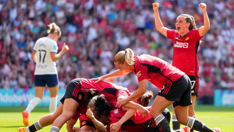 Rachel Williams, on the ground, was mobbed by her teammates after scoring United's second goal. - Kirsty Wigglesworth/AP
