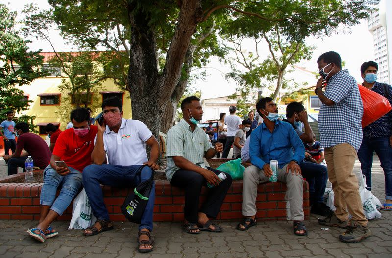 Migrant workers from Bangladesh wear masks as they enjoy a day off on a weekend in Singapore