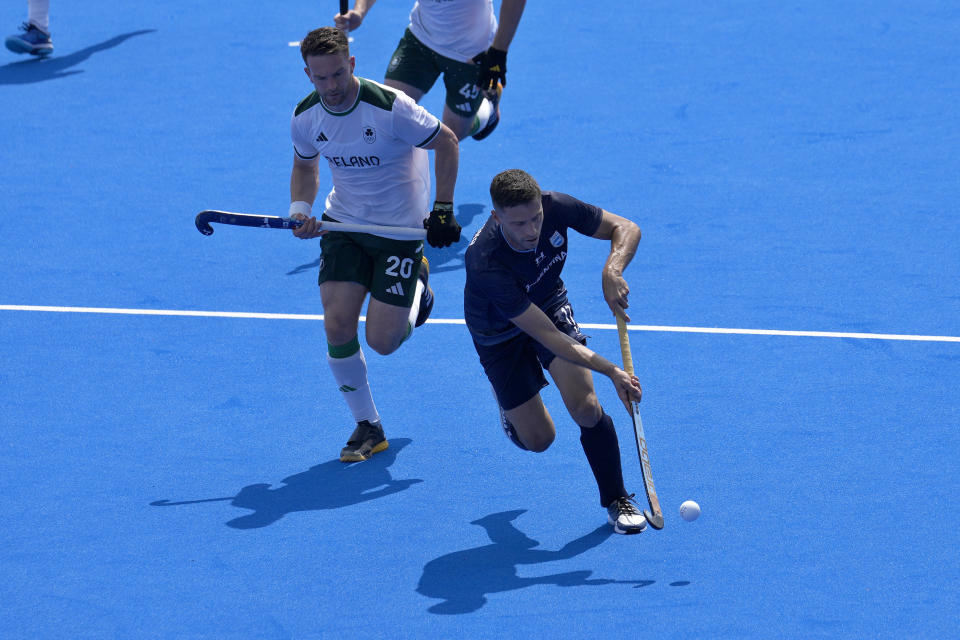 El argentino Santiago Tarazona, a la derecha, conduce la pelota perseguido por el irlandés Jeremy Duncan durante el encuentro por el Grupo B del hockey sobres césped de los Juegos Olímpicos en el estadio Yves-du-Manoir, jueves 1 de agosto de 2024, Colombes, Francia. (AP Foto/Anjum Naveed)