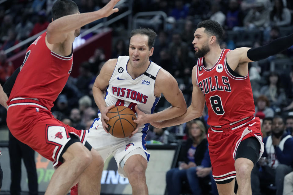 Detroit Pistons forward Bojan Bogdanovic (44) looks to pass as Chicago Bulls center Nikola Vucevic, left, and guard Zach LaVine (8) defend during the first half of an NBA basketball game, Wednesday, March 1, 2023, in Detroit. (AP Photo/Carlos Osorio)