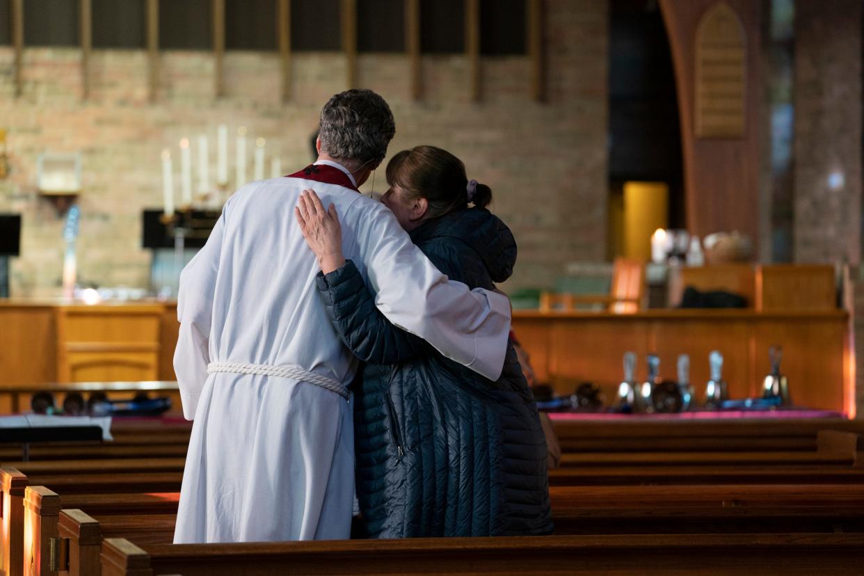 Fr. (the Very Rev.) Chris Yaw of St. David's Episcopal Church in Southfield, left, greets congregation members before delivering Good Friday services on Friday, March 29, 2024.