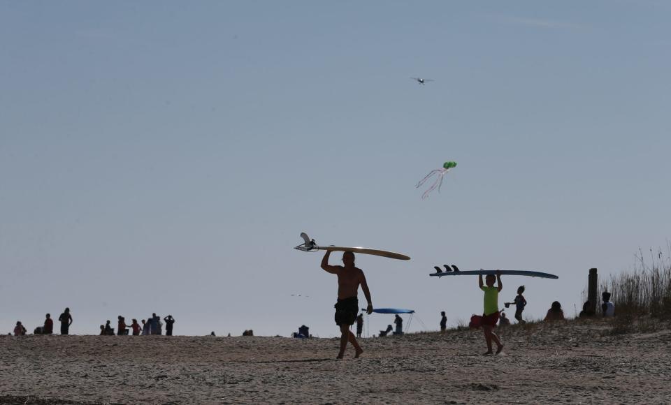 Surfers head out to the ocean on Tybee Island.