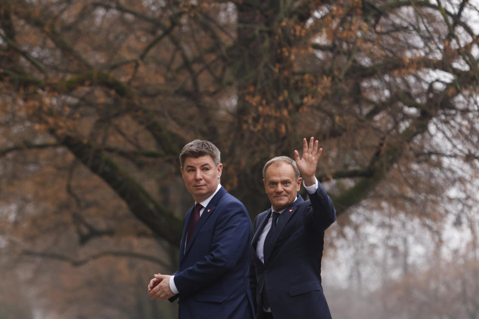 The new Polish Prime Minister Donald Tusk, right, and Jan Grabiec, chief of staff, arrive at the Prime Minister's office in Warsaw, Poland, Wednesday, Dec. 13, 2023. (AP Photo/Michal Dyjuk)