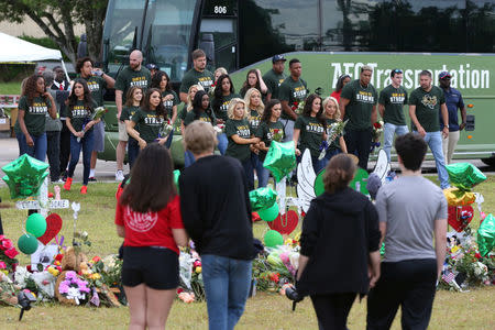 Members of the Houston Texans organization pay their respects at a makeshift memorial left in memory of the victims killed in a shooting at Santa Fe High School in Santa Fe, Texas, U.S., May 23, 2018. REUTERS/Loren Elliott