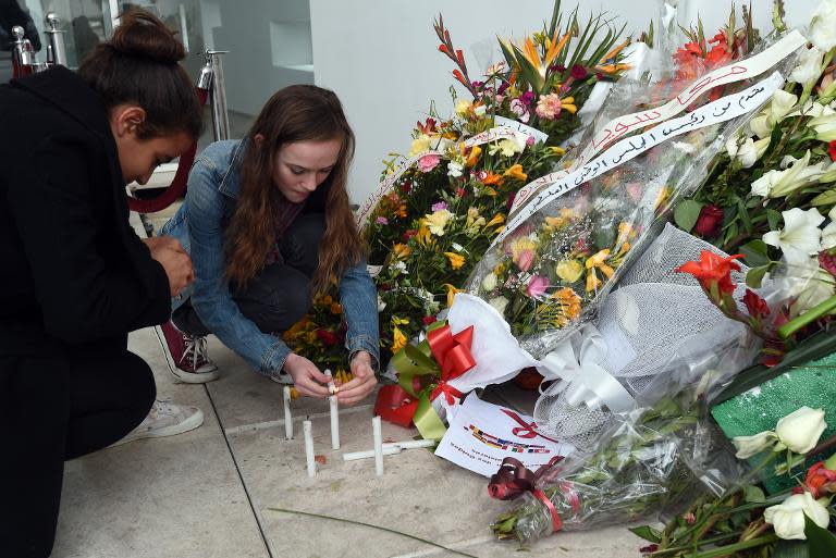 Tourists light candles at the national Bardo Museum in Tunis in memory of the victims of the March attack