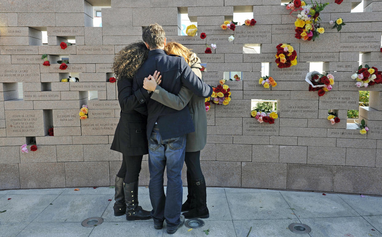 A woman is consoled after having placed flowers on a memorial wall during the American Airlines Flight 587 10th-anniversary memorial at Belle Harbor in Queens, N.Y., on Nov. 12, 2011. (Kathy Kmonicek / AP file)