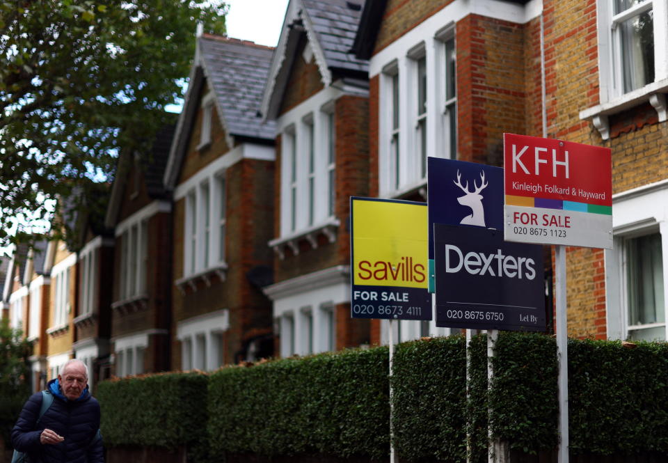 A man walks past houses ‘For Sale’ in a residential street in London, Britain, September 27, 2022. REUTERS/Hannah McKay