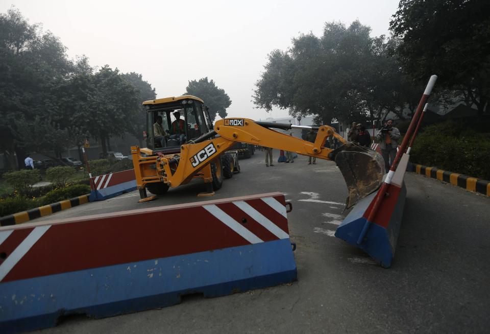 A bulldozer removes the security barriers in front of the U.S. embassy in New Delhi December 17, 2013. Indian authorities removed security barriers in front of the U.S. embassy in New Delhi on Tuesday apparently in retaliation for the arrest and alleged heavy-handed treatment of an Indian diplomat in New York. New Delhi police used tow trucks and bulldozers to remove the concrete barricades, which are used to restrict traffic on the road outside the embassy. REUTERS/Adnan Abidi (INDIA - Tags: POLITICS)