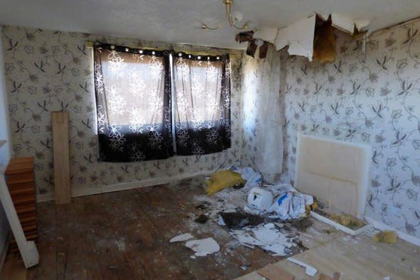 A dilapidated room with the ceiling falling in.