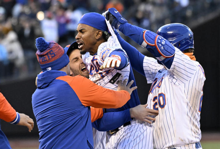 New York Mets' Francisco Lindor (12) celebrates with teammates after hitting a single to drive in the winning run during the 10th inning of the first game of a baseball double-header against the San Francisco Giants Tuesday, April 19, 2022, in New York. The Mets won 5-4.(AP Photo/Bill Kostroun)