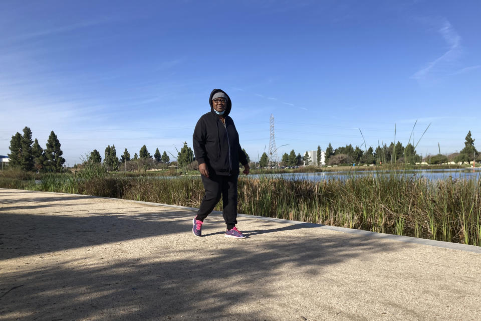 Barbara Washington Prudhomme walks around a lake at Earvin "Magic" Johnson Park in Willowbrook, Calif., on Wednesday, Jan. 18, 2023. The lake is part of a system designed to filter and recycle stormwater runoff for the lake and irrigation and prevent it from washing out to sea. (AP Photo/Brian Melley)