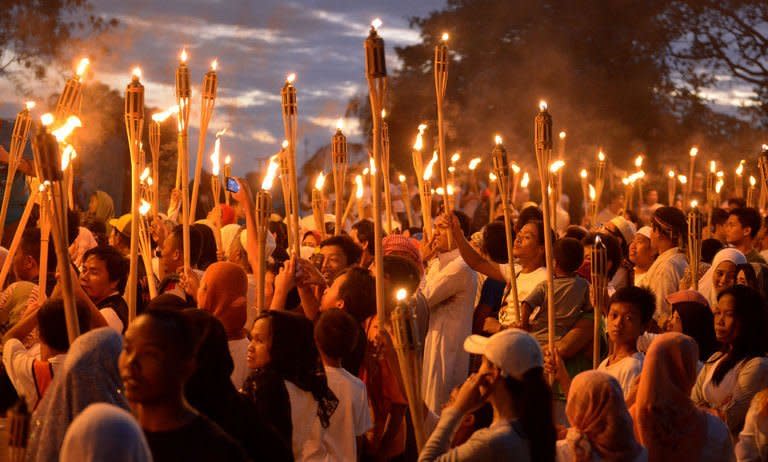 Supporters of the self-proclaimed Sultan of Sulu Jamalul Kiram hold a torchlight parade near a mosque in Manila on March 6, 2012