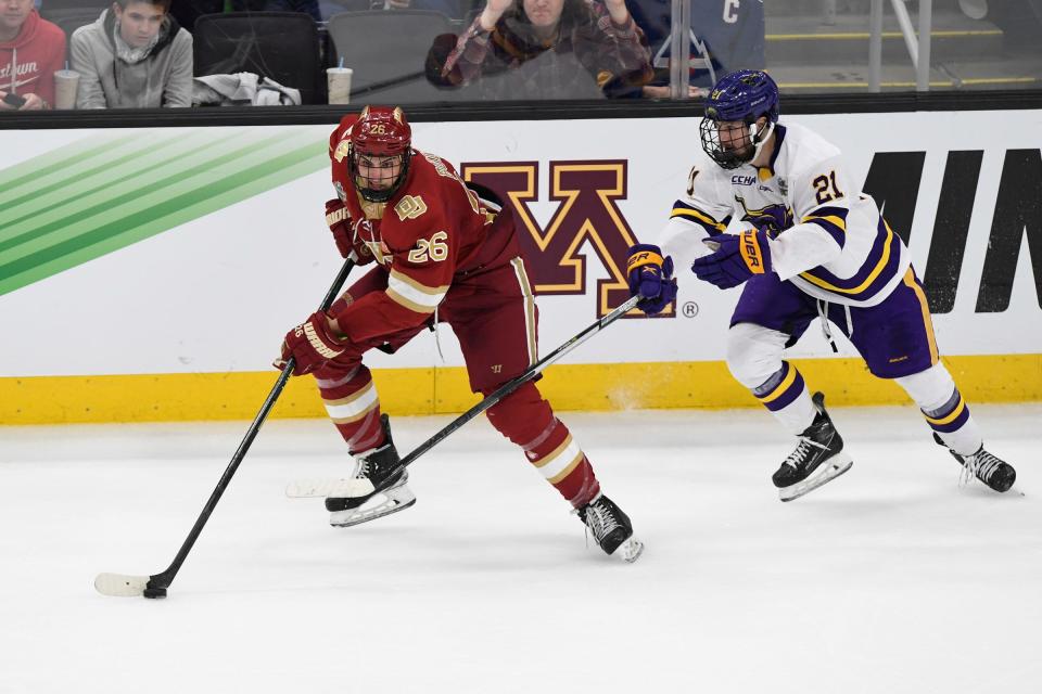 Denver Pioneers defenseman Shai Buium (26) controls the puck in front of Minnesota State Mavericks forward Lucas Sowder (21) during the second period of the 2022 Frozen Four national championship game at TD Garden in Boston on Saturday, April 9, 2022.