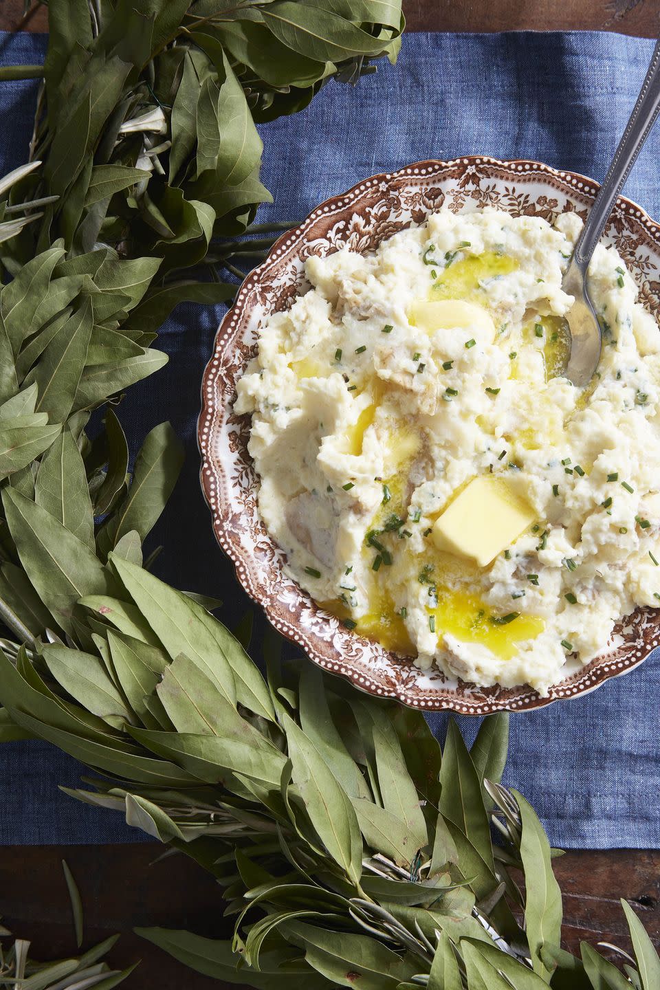 horseradish sour cream mashed potatoes in a vintage antique serving bowl with butter on top and a spoon for serving