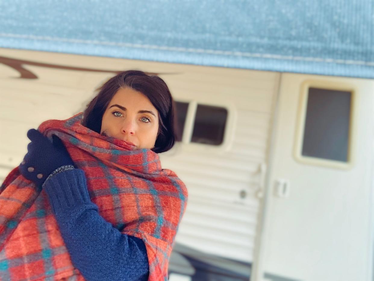 Beautiful middle age woman, enjoying the outdoors near her camper parked nearby. She is wearing a red flanneled scarf wrap, covering part of her face, enjoying the moment. Taken in Wisconsin, USA. Part of a series.