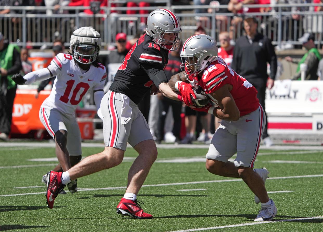 Apr 13, 2024; Columbus, OH, USA; Ohio State Buckeyes quarterback Will Howard (18) hands the ball off to Ohio State Buckeyes running back TreVeyon Henderson (32) during the Ohio State football spring game at Ohio Stadium.