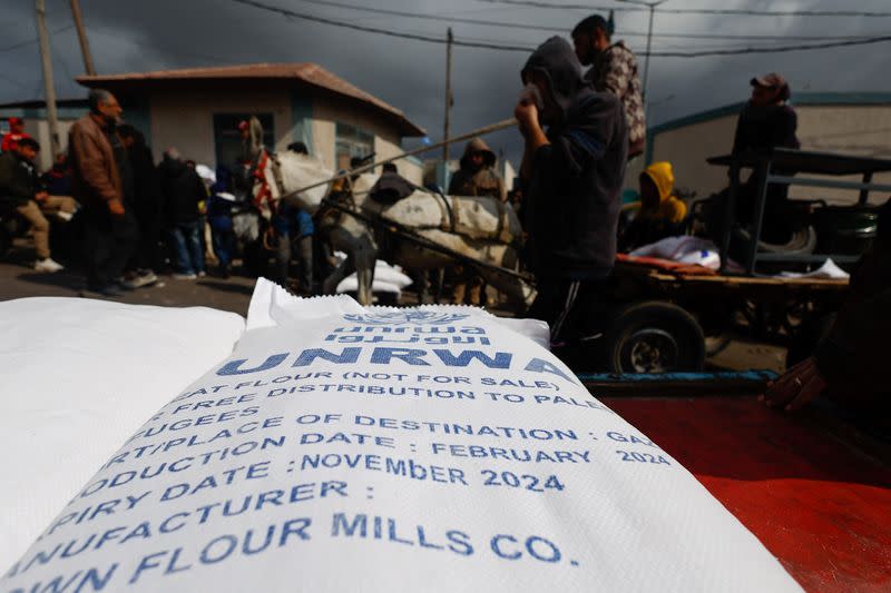 Displaced Palestinians wait to receive United Nations Relief and Works Agency (UNRWA) aid, in Rafah