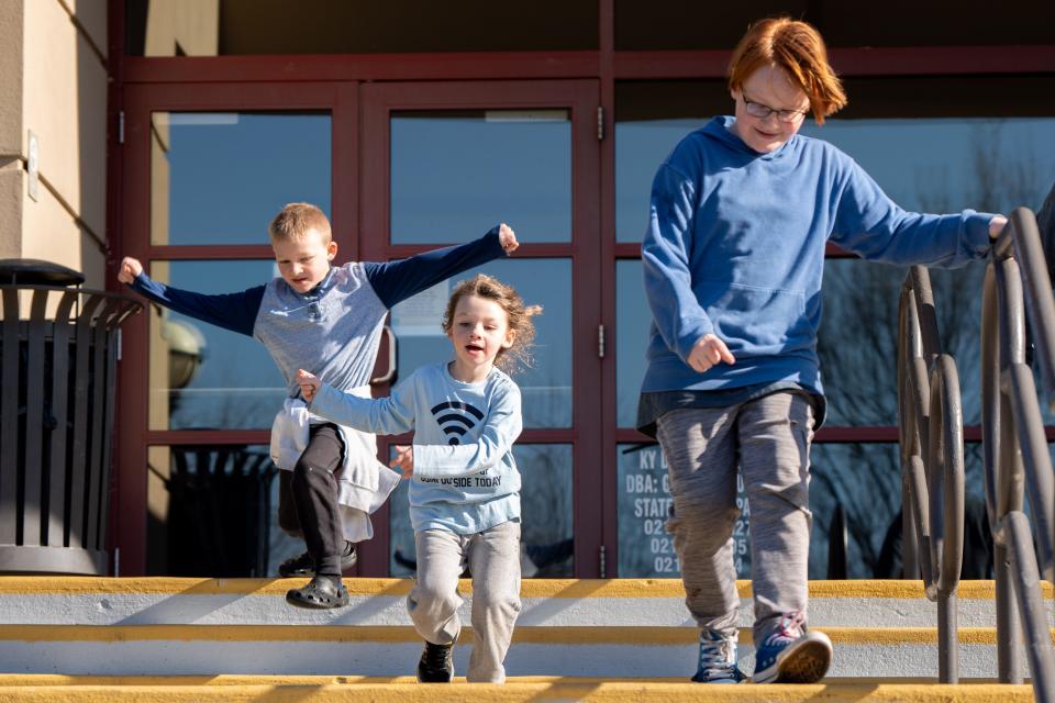 Atlas, 7, Miles, 4, and Ruben Jones, 9, play on the steps of the General Butler State Resort Park Conference Center on Saturday, March 16, 2024 in Carrollton Ky. after having to stay at the resort due to the tornado that came through Milton, Ky. on Thursday, March 14.