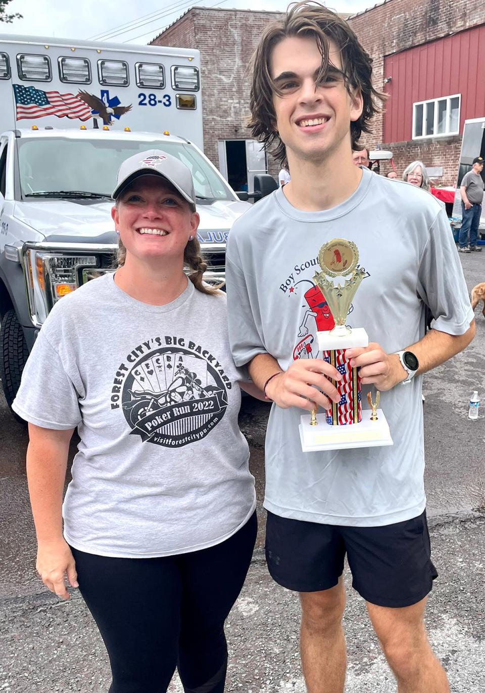 Firecracker 5K co-chair Chrissy Franceski (left) presents the trophy for overall winner of the 2023 race in Pleasant Mount to Nathaniel McKee.