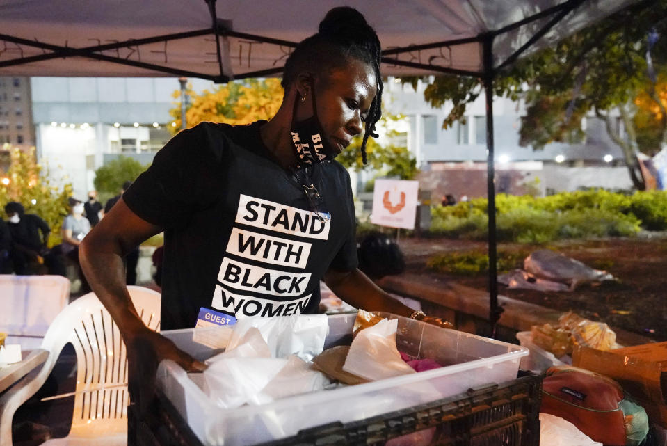 Rose Henderson helps out at a booth in Jefferson Square Park, Thursday, Sept. 24, 2020, in Louisville, Ky. A grand jury has indicted one officer on criminal charges six months after Breonna Taylor was fatally shot by police in Kentucky. The jury presented its decision against fired officer Brett Hankison Wednesday to a judge in Louisville, where the shooting took place. (AP Photo/Darron Cummings)