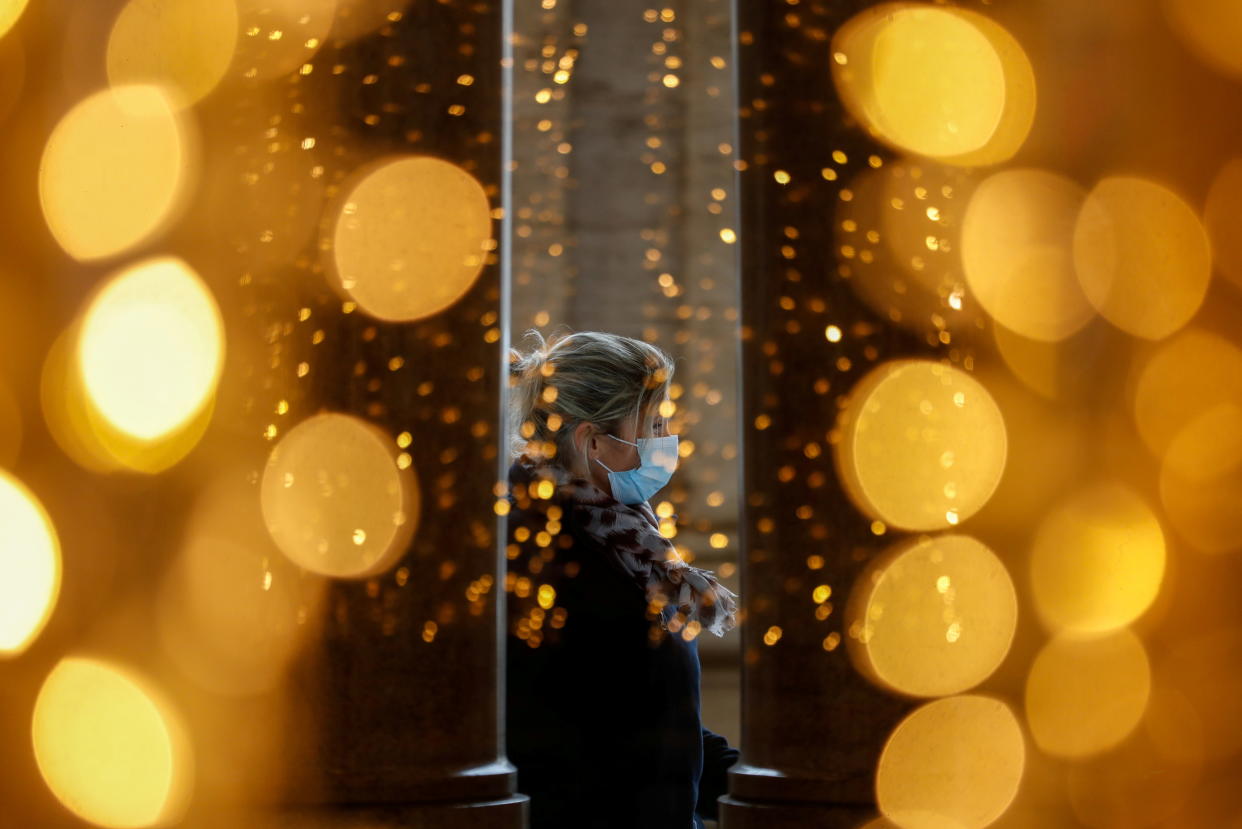 A woman wearing a protective mask is seen through a glass at a shopping centre on the day Italian Health Minister Roberto Speranza lays out in parliament the government's plan for mass coronavirus disease (COVID-19) vaccinations and restrictions over the Christmas period, in Rome, Italy December 2, 2020. REUTERS/Yara Nardi     TPX IMAGES OF THE DAY