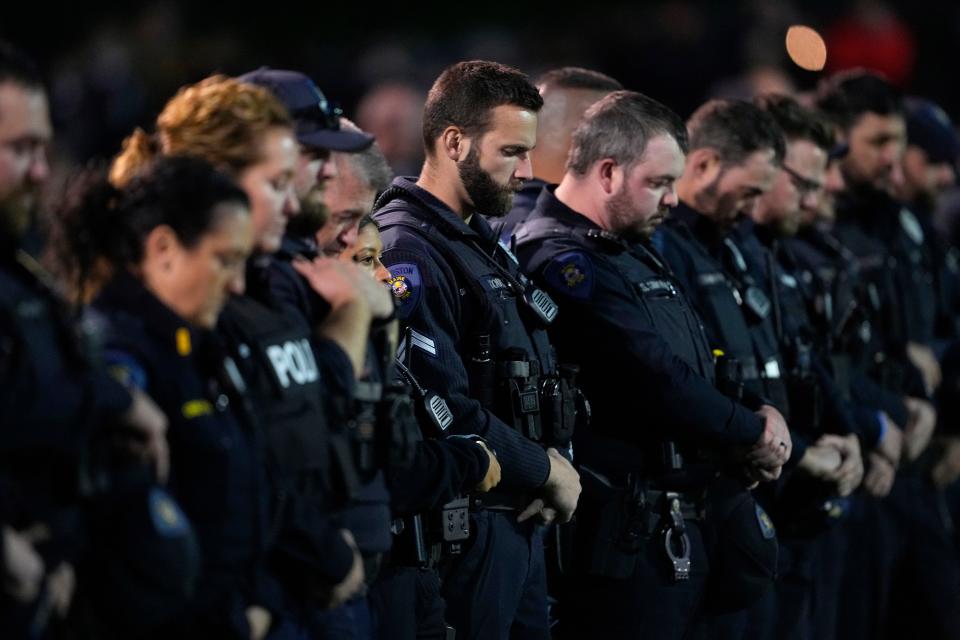 Lewiston Police officers stand during a moment of silence for the victims of the Lewiston shooting, Wednesday, Nov. 1, 2023, prior to a high school football game between Lewiston High School and Edward Little High School in Lewiston, Maine. Locals seek a return to normalcy after the mass shooting on Oct. 25. (AP Photo/Matt York)