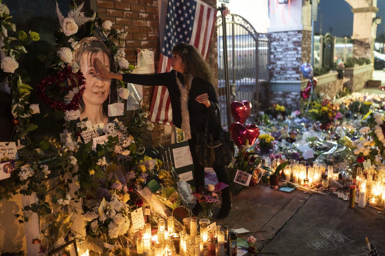 Adele Castro touches the photo of Mymy Nhan at a memorial crowded with bouquets and candles.