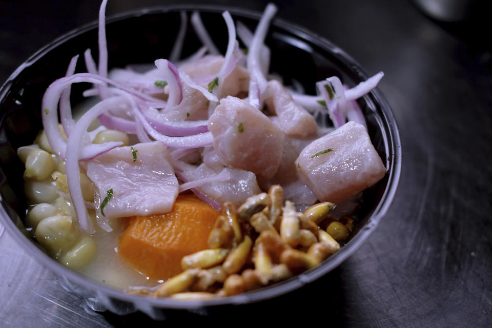 In this Aug. 8, 2019 photo, a Peruvian ceviche is ready for a costumer at the international center outside the Pan American athletes' village in Lima, Peru. Peruvian food was the star at the recent Pan Am Games held in Latin America’s culinary capital. Athletes from countries across the Americas tasted the highly-regarded cuisine that blends indigenous traditions with European, African and Asian influences with an abundance of seafood from the Pacific Ocean’s cold Humboldt current. (AP Photo/Luis Andres Henao)