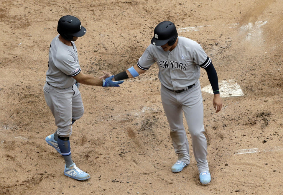 New York Yankees' Brett Gardner, left, celebrates with Gio Urshela after scoring on a two-run single by Austin Romine during the third inning of a baseball game against the Chicago White Sox in Chicago, Sunday, June 16, 2019. (AP Photo/Nam Y. Huh)