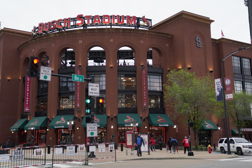 People walk outside Busch Stadium after the scheduled start of a baseball game between the St. Louis Cardinals and the New York Mets Tuesday, May 4, 2021, in St. Louis. The game has been rained out and the two teams will play a doubleheader on Wednesday. (AP Photo/Jeff Roberson)