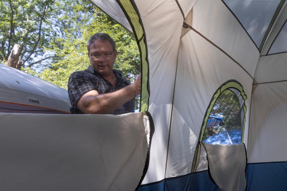 The Rev. Steve Brigham put up a tent for a camper at a homeless camp in the woods in Toms River on August 11, 2023.