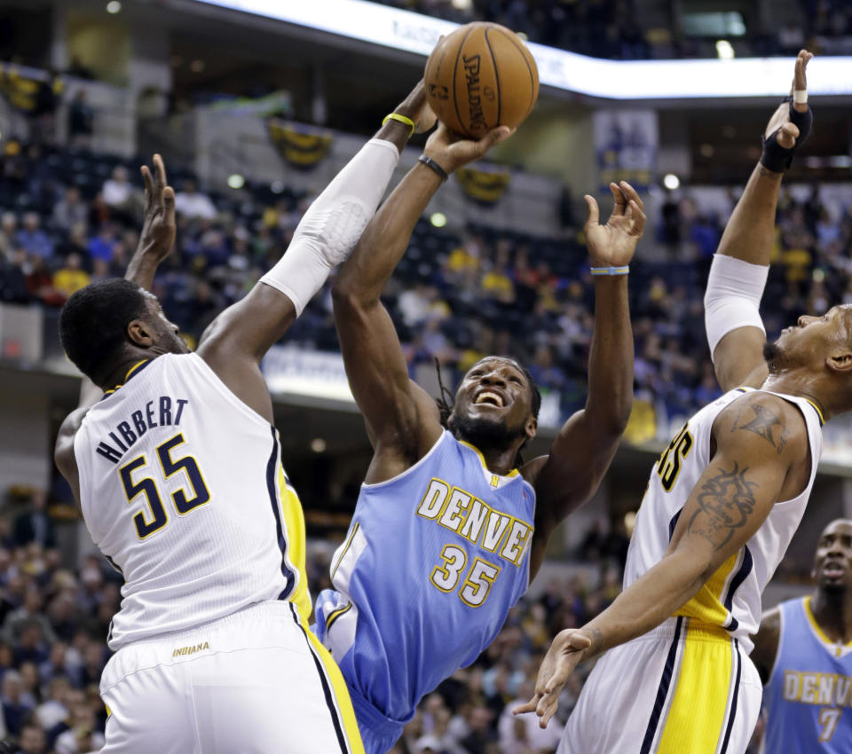 Denver Nuggets forward Kenneth Faried (35) shoots between Indiana Pacers center Roy Hibbert (55) and David West in the first half of an NBA basketball game in Indianapolis, Monday, Feb. 10, 2014. (AP Photo/Michael Conroy)