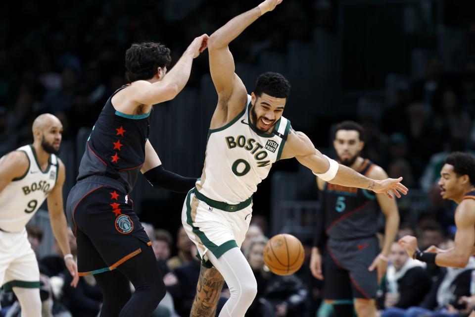 Boston Celtics' Jayson Tatum (0) loses control of the ball next to Washington Wizards' Deni Avdija, front left, during the first half of an NBA basketball game, Friday, Feb. 9, 2024, in Boston. (AP Photo/Michael Dwyer)