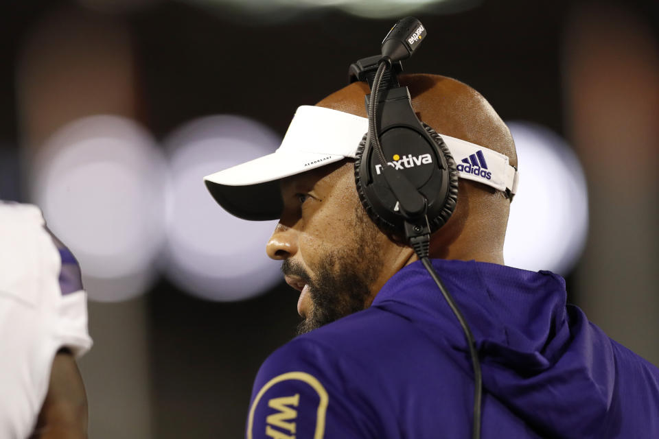 Washington coach Jimmy Lake talks to a player during the first half of the team's NCAA college football game against Arizona on Friday, Oct. 22, 2021, in Tucson, Ariz. (AP Photo/Chris Coduto)