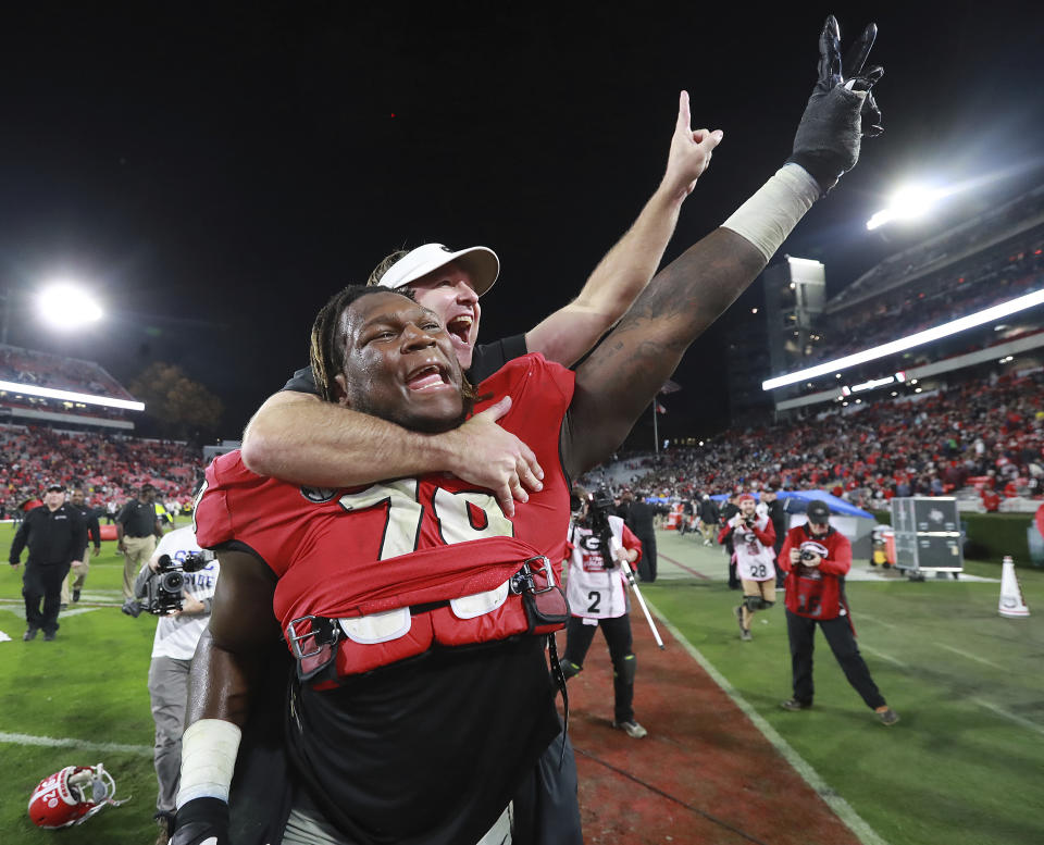 Georgia head coach Kirby Smart jumps on the back of offensive lineman Isaiah Wilson to celebrate beating Texas A&M 19-13 in an NCAA college football game Saturday, Nov. 23, 2019, in Athens, Ga. (Curtis Compton/Atlanta Journal-Constitution via AP)