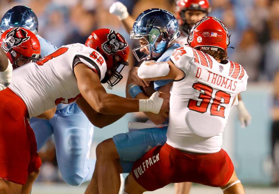 N.C. State linebacker Drake Thomas (32) and defensive end Travali Price (58) sack North Carolina quarterback Drake Maye (10) during the second half of N.C. State’s 30-27 overtime victory over UNC at Kenan Stadium in Chapel Hill, N.C., Friday, Nov. 25, 2022.