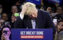 El primer ministro británico, Boris Johnson, se toca la cabeza durante el último acto de su partido antes del cierre de campaña de las elecciones generales en Londres (Reino Unido) el 11 de diciembre. (Foto: Hannah McKay / Reuters).