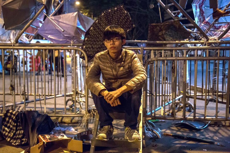 Joshua Wong, then 17 and leader of the pro-democracy group Scholarism, sits on steps alongside metal security barriers outside the Central Government Offices in the Admiralty district of Hong Kong, China, on Wednesday, Dec. 10, 2014.