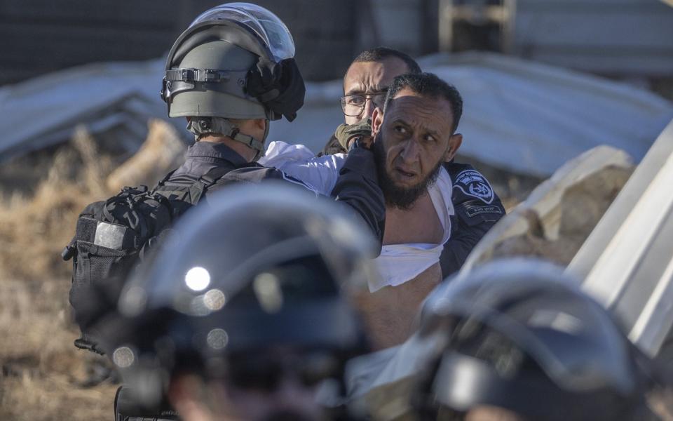 Israeli police arrest a Bedouin man during the demolishing of unrecognised Bedouin village of Wadi al-Khalil