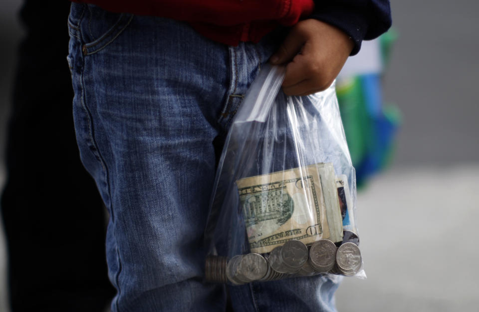 A boy carries cash to visit his mother at California Institute for Women state prison in Chino, California May 5, 2012. An annual Mother's Day event, Get On The Bus, brings children in California to visit their mothers in prison. Sixty percent of parents in state prison report being held over 100 miles (161 km) from their children.  Picture taken May 5, 2012   REUTERS/Lucy Nicholson (UNITED STATES - Tags: CRIME LAW SOCIETY)  ATTENTION EDITORS PICTURE 09 OF 28 FOR PACKAGE 'MOTHER'S DAY BEHIND BARS'