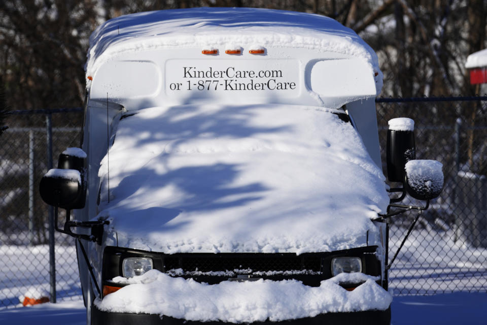 A day care bus is covered by snow in the Chicago suburb of Wheeling, Ill., Sunday, Jan. 14, 2024. Wind chill warning is in effect as dangerous cold conditions continue in the Chicago area. (AP Photo/Nam Y. Huh)